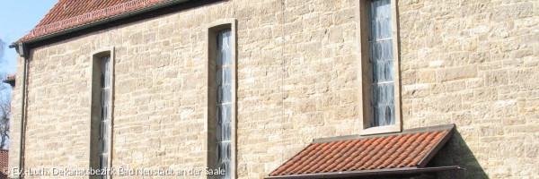 Eine Kirchenwand mit drei Fenstern von außen gesehen