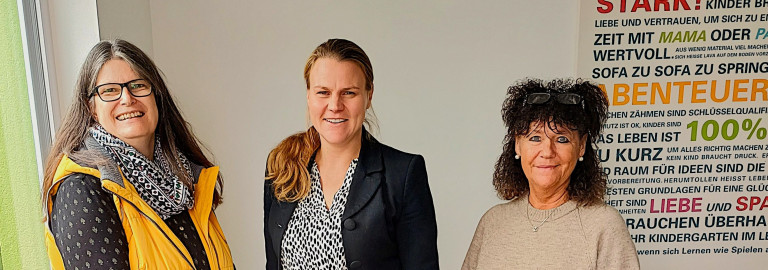 Pfarrerin Beate Hofmann-Landgraf, Sonja Riley und KiTa-Leiterin Ingrid Wirsing im Eingangsbereich der KiTa in Höchheim